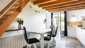 Una cocina moderna con armarios blancos, encimera blanca y horno empotrado.