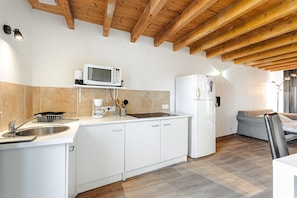 A modern kitchen with white cabinetry, a microwave, a refrigerator, and a sink.