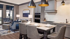 A modern kitchen with a central island, grey cabinetry, and pendant lighting. - Charleston | Couples Historic Getaway | Gym + Concierge (Charleston)