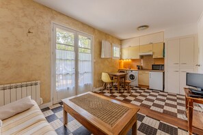Um espaço compacto com cozinha compacta, área de refeições e cama.