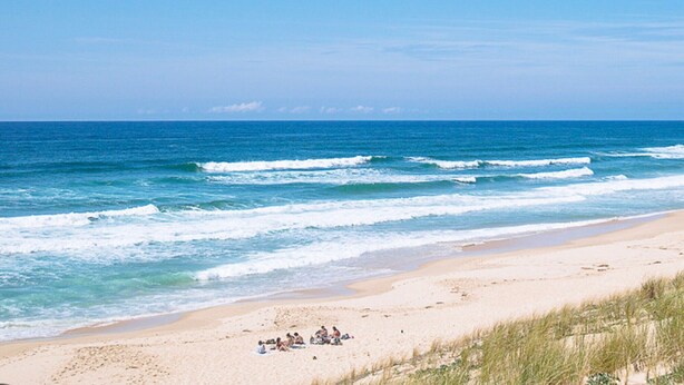 A beach with waves, a sandy shore, and a group of people. - Charming Studio Cap Ferret Phare (Lège-Cap-Ferret)