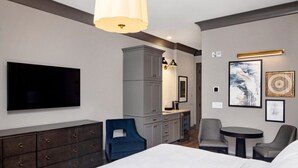 Une chambre d’hôtel moderne équipée d’un lit, d’une télévision, d’un bureau et d’une chaise.