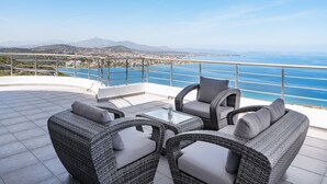 A terrace with wicker furniture, a glass table, and a view of the sea and distant mountains. - Apartment "Villa Coral - First Floor" with Private Pool & Wi-Fi (Chamolia)