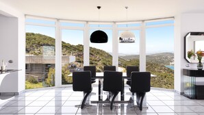 A modern dining area with a panoramic view of a hilly landscape, a large window, and a black ceiling light. - Apartment "Villa Coral - First Floor" with Private Pool & Wi-Fi (Chamolia)