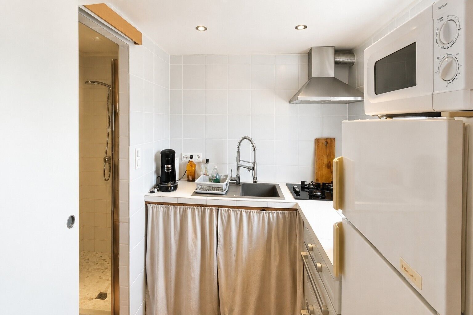 A compact kitchen with a sink, stove, and microwave.