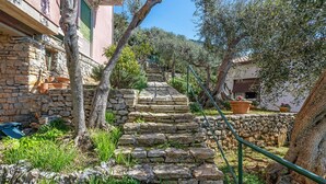 A stone staircase leading to a building with a stone wall and potted plants. - Apartment 'Amazing View' with Private Terrace, Wi-Fi and Air Conditioning (Tellaro)