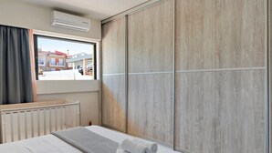 Une chambre d’hôtel avec un lit, une fenêtre, un radiateur et une armoire.
