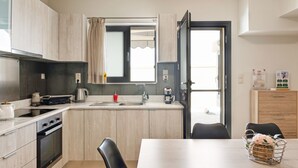 Une cuisine de taille réduite comprenant une cuisinière, un évier et un coin repas.