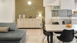 A modern kitchen with a dining area, a sofa, and a decorative wall piece. - Apartment "Theo and Ms Luxurious" with Private Terrace & Wi-Fi (Kos)