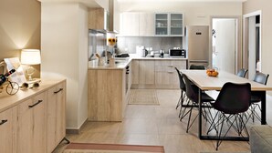 A modern kitchen with a dining area, wooden cabinets, and a central island. - Apartment "Theo and Ms Luxurious" with Private Terrace & Wi-Fi (Kos)