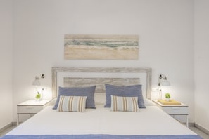 A bedroom with a large bed, two bedside tables with lamps, a wall-mounted painting, and a headboard. - Holiday Home 'Ca Ses Celleres' with Private Terrace, Private Garden and Wi-Fi (Illes Balears)