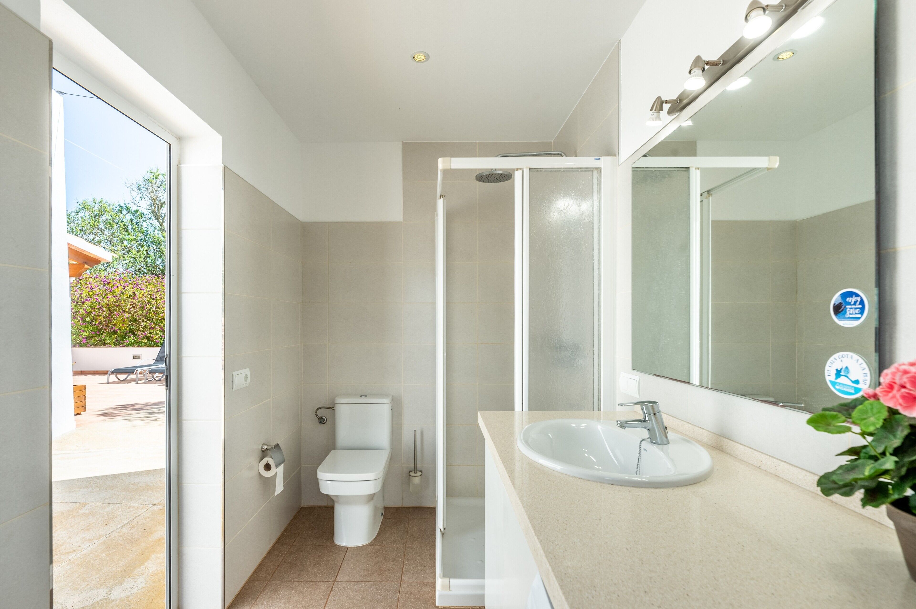 Un bagno moderno con toilette, doccia, lavandino e uno specchio grande.