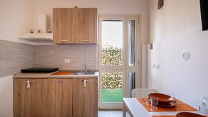 Une cuisine compacte dotée de meubles en bois, d’un évier et d’un coin repas avec une table et des chaises.