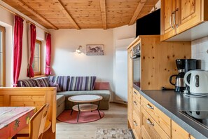 Una cocina acogedora con armarios de madera, una mesa de comedor y un sofá.