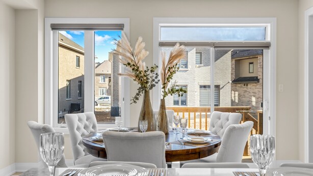 A dining area with a table set for four, large windows, and a view of the neighborhood. - Executive 5BR-4BATH Detached Retreat Brampton/Miss Border  (Brampton)