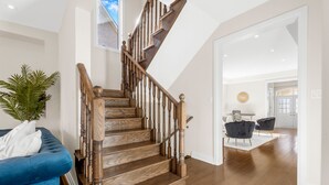 A staircase with wooden balusters and a blue couch in the foreground. - Executive 5BR-4BATH Detached Retreat Brampton/Miss Border  (Brampton)