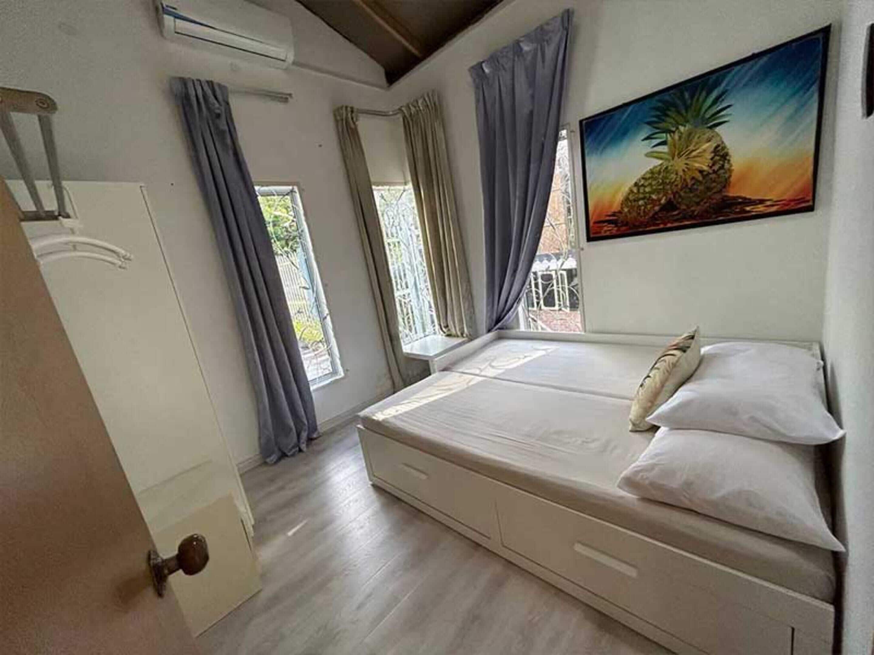 A bedroom with a bed, a window, and a door.