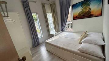 A bedroom with a bed, a window, and a door.