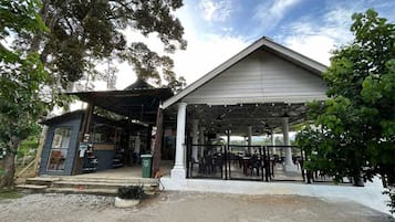 Um edifício com área de estar coberta e uma estrutura menor adjacente.