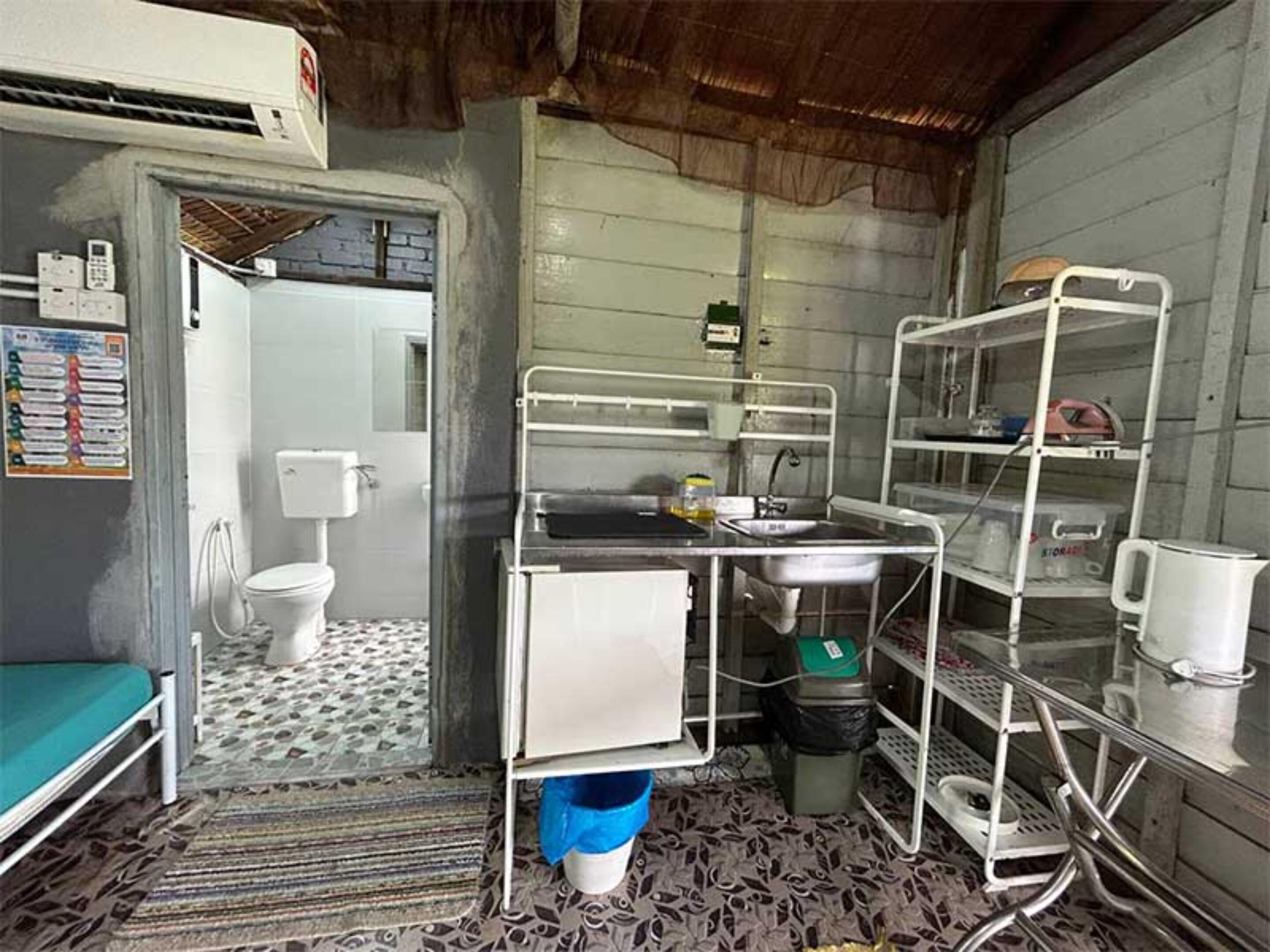 Una cocina compacta con un lavamanos, estufa y un refrigerador pequeño.