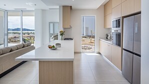 Una cocina moderna con una isla central, electrodomésticos de acero inoxidable y vistas al paisaje desértico.