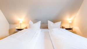 A twin room with two beds, each with a nightstand and a lamp.