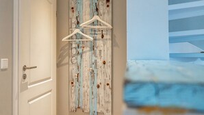 En gang med en dør, en træpanel på væggen med et rustikt design, og en hvid knagerække.