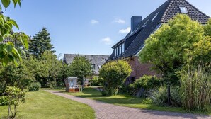 Il s'agit d'une propriété résidentielle dotée d'une allée pavée, d'une maison en briques et d'un jardin bien entretenu.