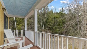 A covered porch with white railings and two white Adirondack chairs. - Gorgeous 3 bedroom in popular Stowe location. (Stowe)