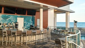 Angolo bar con posti a sedere e vista sul mare.