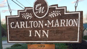 Une enseigne en bois indiquant le Carlton-Marion Inn, avec l’adresse 309 West Old Main.
