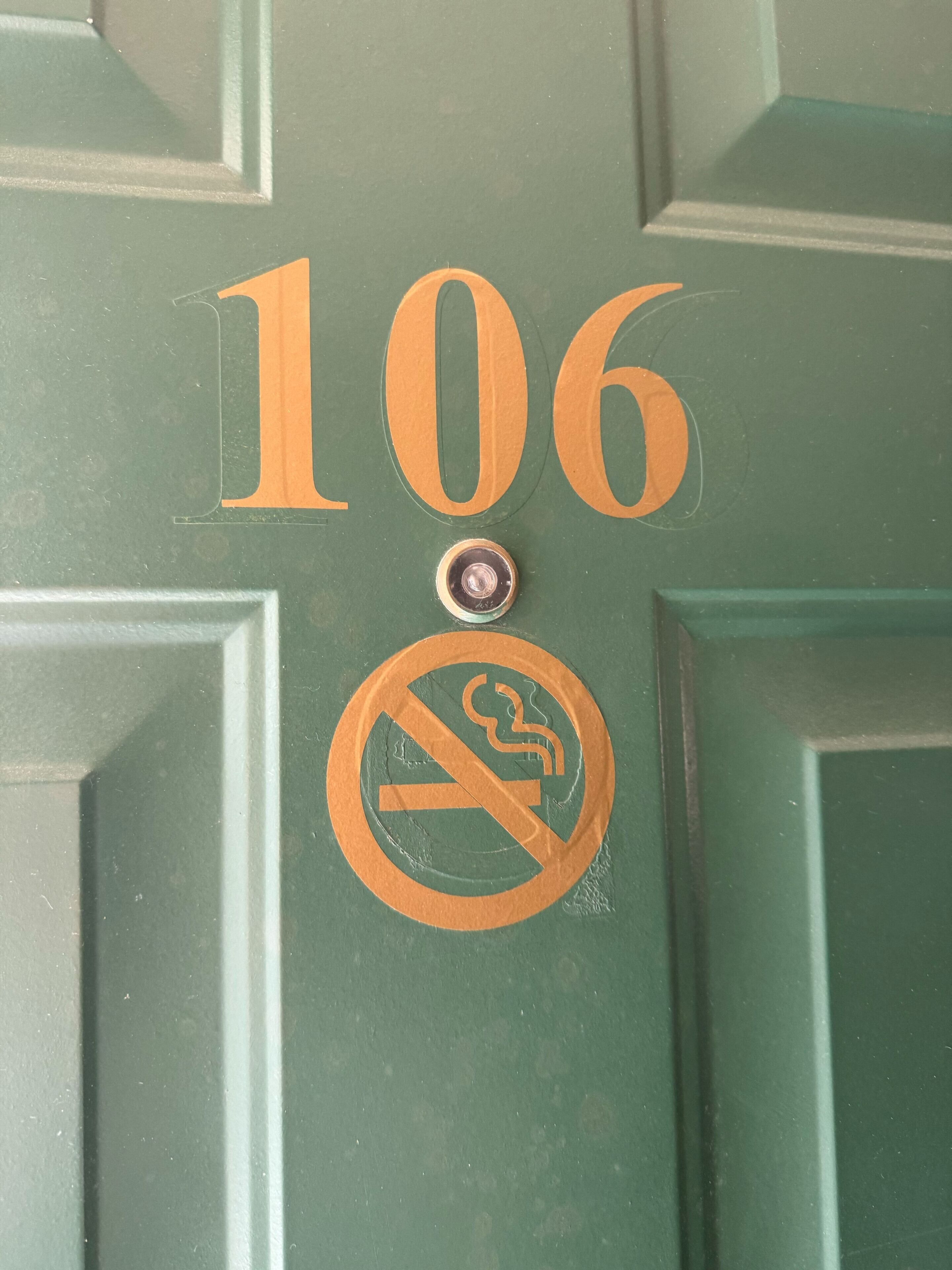 Vihreä ovi, jonka numerona on 106, ja tupakointikieltokyltti.