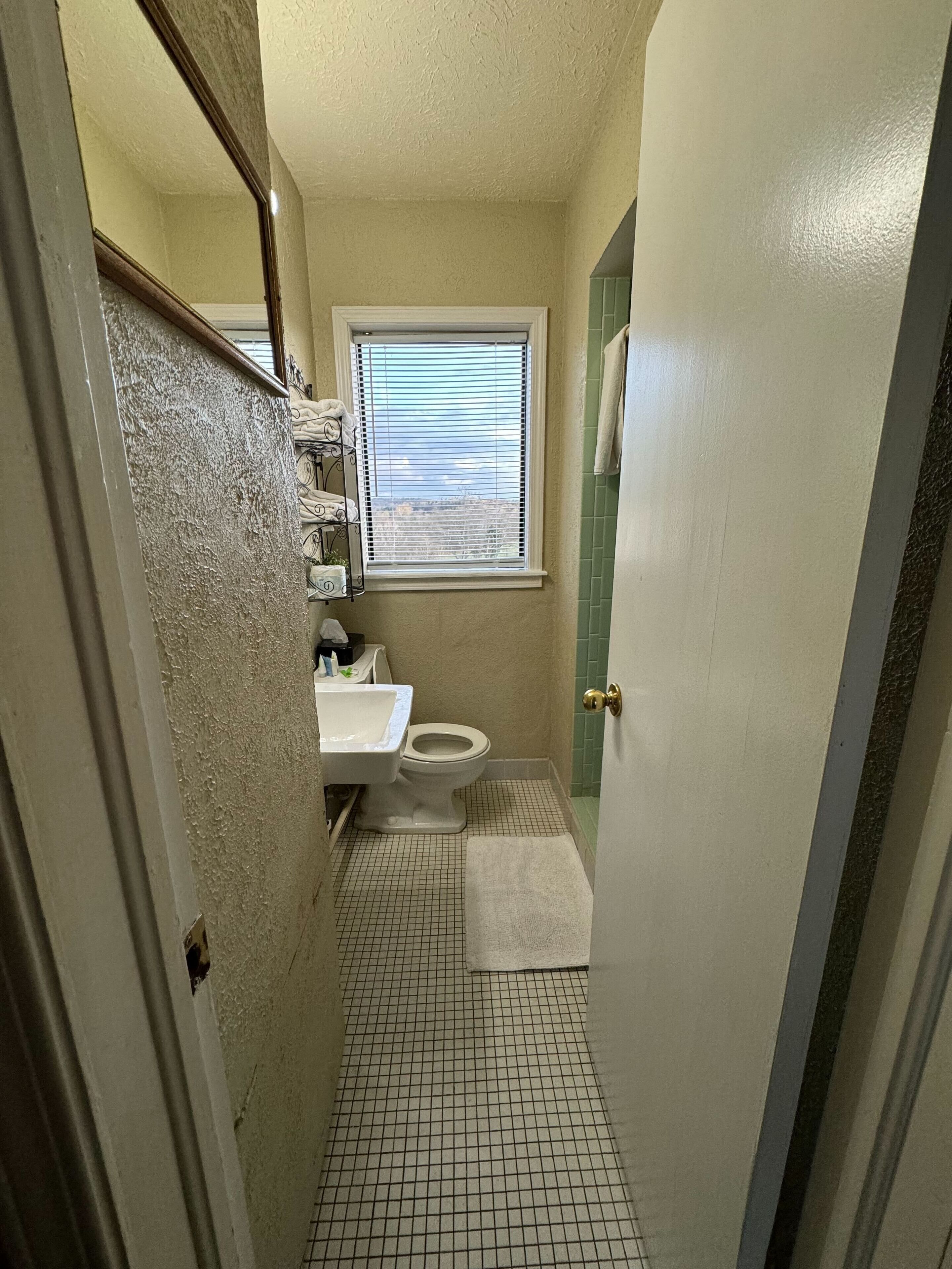 Une petite salle de bain comprenant des toilettes, un lavabo et une fenêtre.