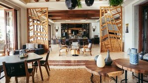 A spacious living area with a wooden ceiling, a bar area, and a seating arrangement. - Los Cabos | Elevated Coastal Retreat | Pool + Beach (Cabo del Sol)