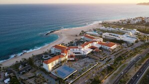 An aerial view of a coastal hotel with multiple buildings, a beach, and a road. - Los Cabos | Elevated Coastal Retreat | Pool + Beach (Cabo del Sol)