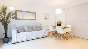 A modern living room with a sofa, two chairs, a dining table, and a potted plant. - CAPDEVILA 9 (Llafranc)