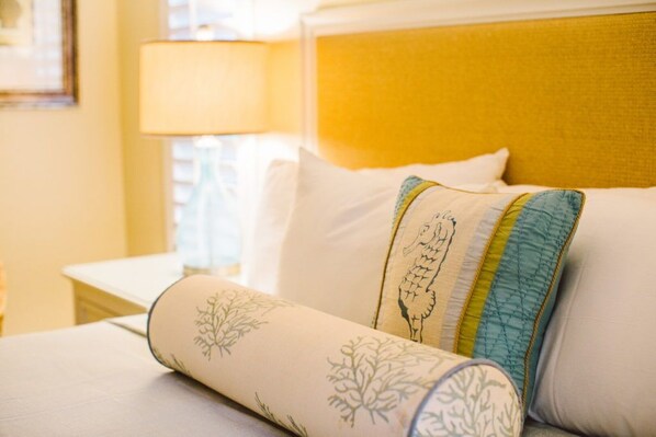 Una cama con almohadones decorativos y un cabecero.