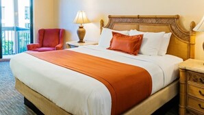 A hotel room with a large bed, a nightstand, a lamp, a chair, and a view of the outdoors.
