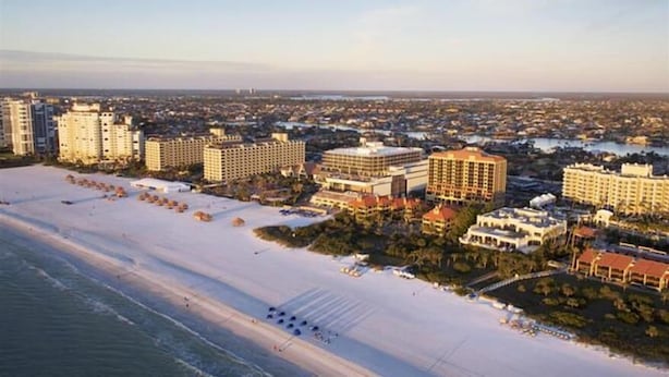 A coastal hotel with multiple buildings, a beach, and a marina. - Marco Island | Family Beach Retreat | Pool + Beach | 2BR (Marco Island)
