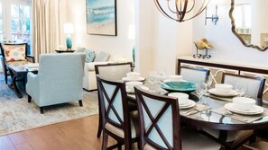 A dining area with a round table set for four, surrounded by chairs.
