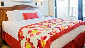 Une chambre d’hôtel avec un lit, une table de chevet en bois et une fenêtre donnant sur un paysage agréable.