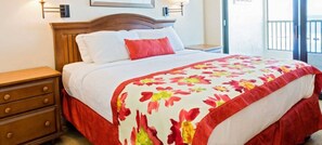 A hotel room with a bed, a nightstand, and a window with a view.