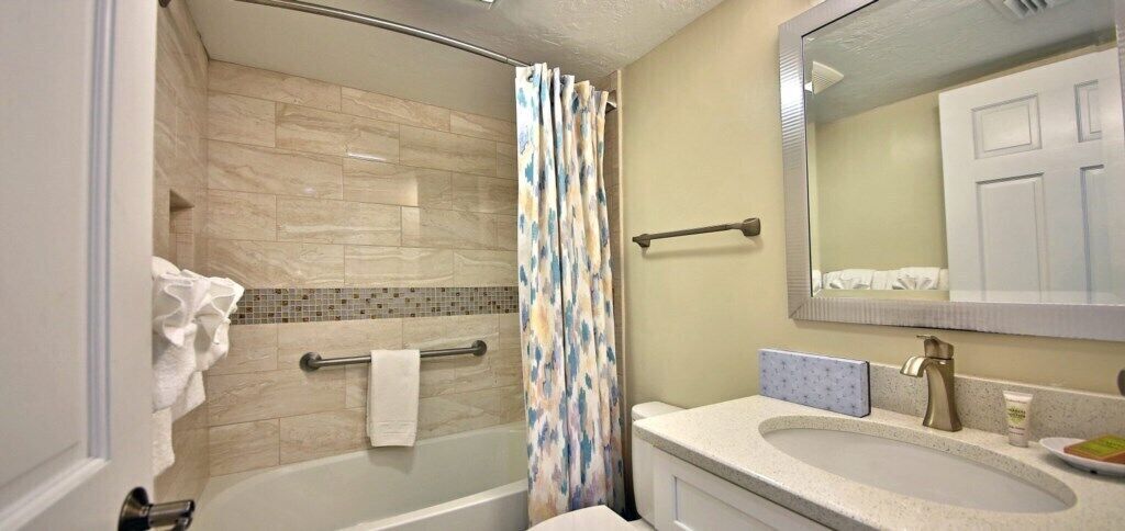 A bathroom with a shower, a bathtub, a sink, and a mirror.