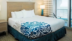 A hotel room with a bed, two bedside tables, a window with a view, and a balcony. - Marco Island | Family Beach Retreat | Pool + Beach | 2BR (Marco Island)