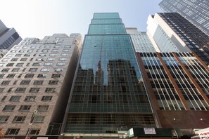 Ein modernes Hochhaus mit Glasfassade, umgeben von weiteren hohen Gebäuden.