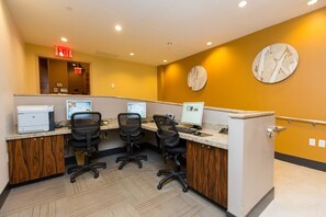 Un espacio de oficina moderno con cubículos, computadoras y un escritorio de madera.