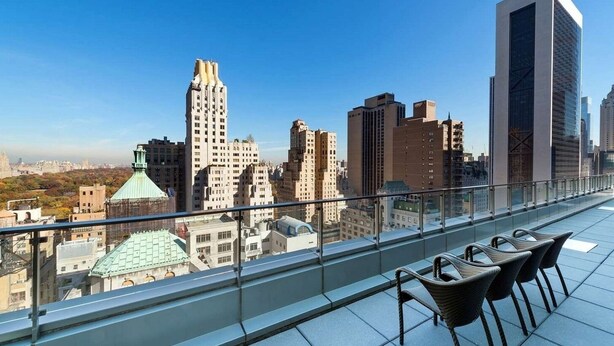 A rooftop terrace with a city view, featuring modern buildings and a clear sky. - New York City | Upscale City Retreat | Broadway, Dining & 5th Ave (New York)