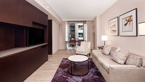 A modern living room with a sofa, a TV, a coffee table, and artwork on the wall. - New York City | Upscale City Retreat | Broadway, Dining & 5th Ave (New York)