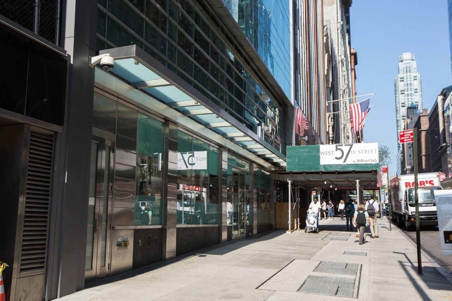 A hotel with a modern facade, large windows, and a sign indicating it's on 57th Street.