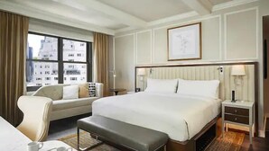A hotel room with a large bed, a sofa, a small table, and a bench. - NYC | Midtown Location | Central Park | 1BR Premier (New York)